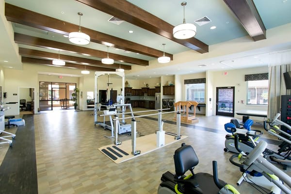 Spacious therapy room with exercise equipment and wooden beams