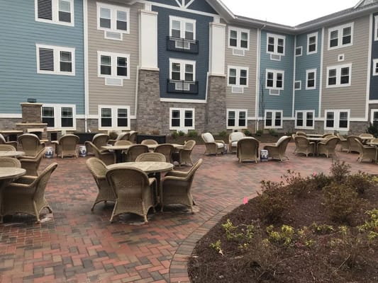 Outdoor seating area with wicker chairs and tables.