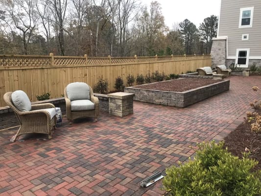 Comfortable seating area on a brick patio surrounded by greenery