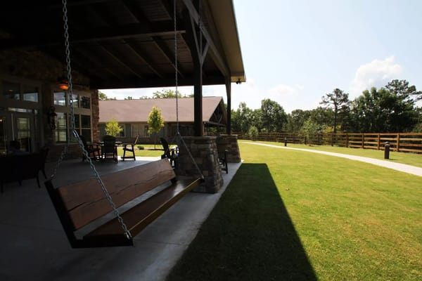 Swinging benches on the patio with a view of the lawn and building
