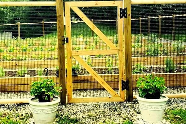 Wooden garden gate with potted plants at The Phyllis Siperstein Tamarisk Assisted Living Residence