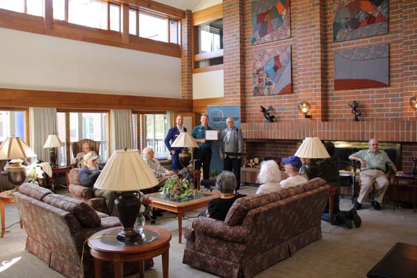 Residents and staff gather in the living room of The Pillars at Crystal Bay.