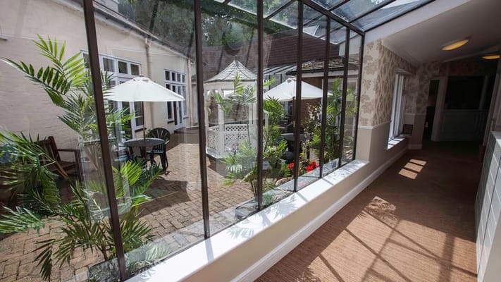 Indoor sunlit hallway leading to outdoor patio area