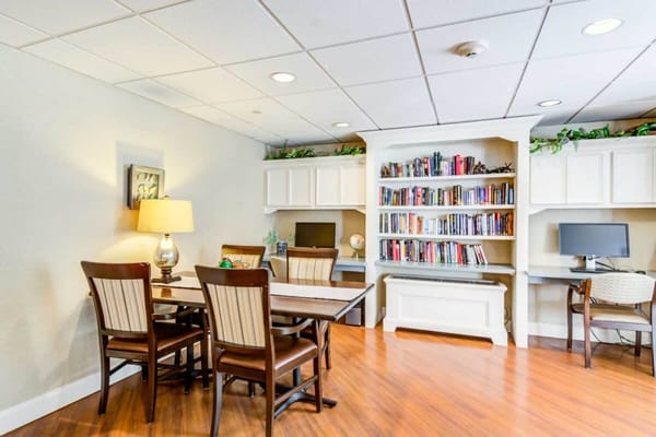 Reading area with chairs, a table, and bookshelves