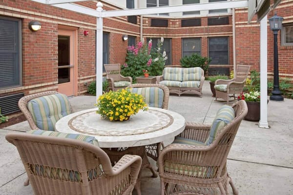 Outdoor seating area with a table and flower pot in a courtyard.