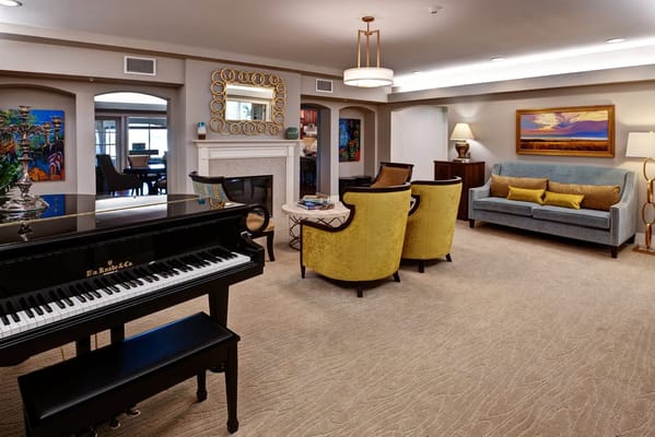 A cozy common area with seating and a piano