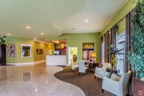 A spacious lobby with green walls and stylish seating