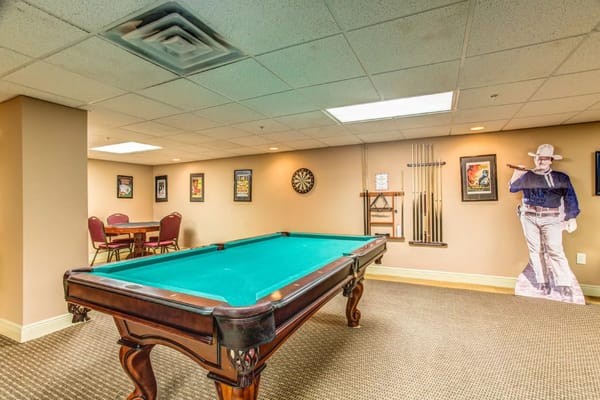 A billiards room with a pool table and dartboard