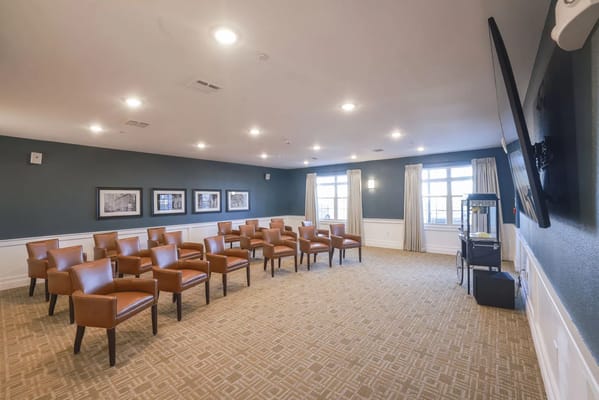 Seating arrangement in a common area with several chairs and a popcorn cart.