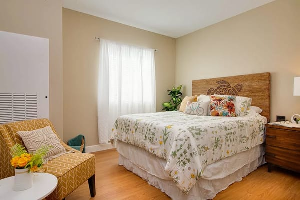 Bright and inviting bedroom with a floral quilt and natural decor.