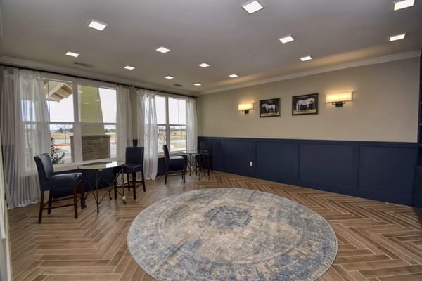 Brightly lit common area with seating and a circular rug