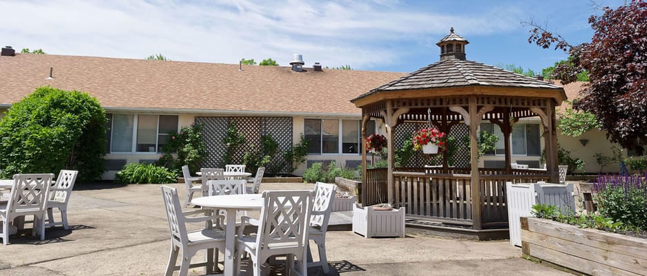 Patio area with chairs and a wooden gazebo