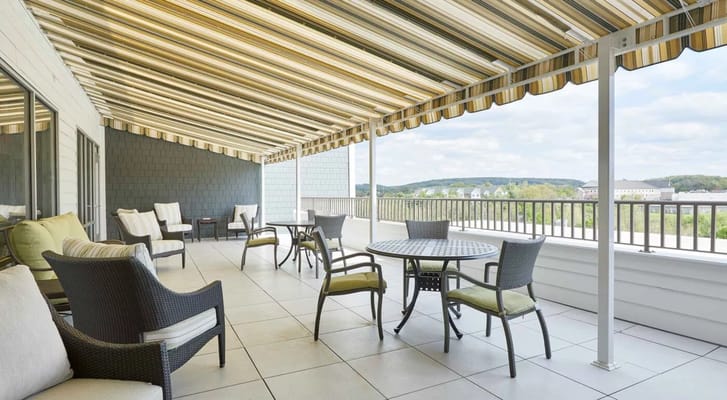 Patio area with seating and tables under an awning