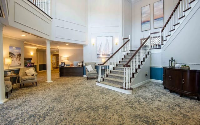 Spacious lobby with staircase and seating area.