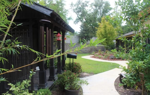A winding garden path surrounded by greenery at The Residence.