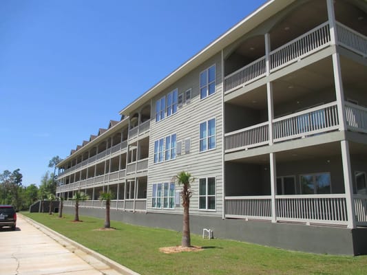 Exterior view of a multi-story building with balconies and palm trees