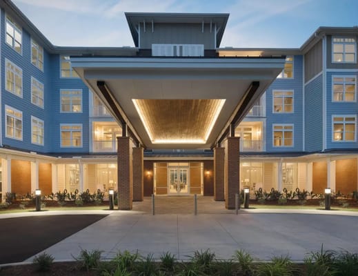 Modern entrance to senior living facility with lit pathway