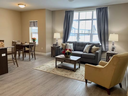 Spacious living room with a sofa, armchair, and dining area