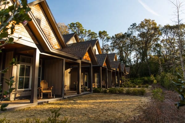 Exterior view of cottages with porches surrounded by greenery