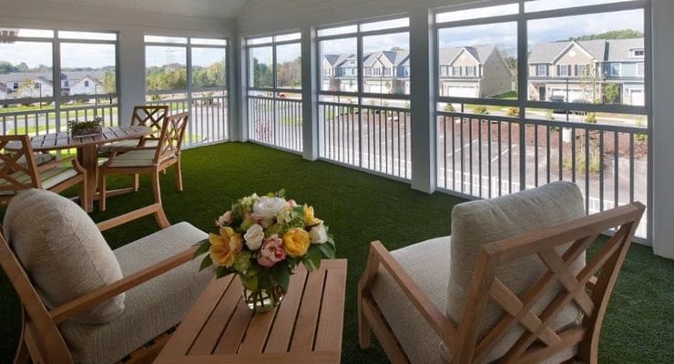 Inviting sunroom with seating and a floral arrangement.