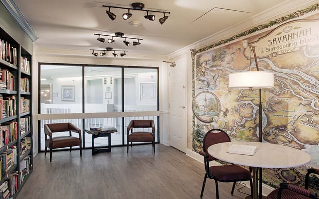 Interior view of a common area with bookshelves and map