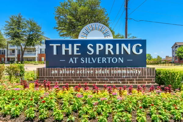 Sign for The Spring at Silverton with colorful flower beds
