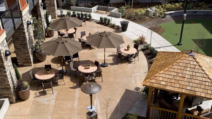 Sunny outdoor patio with tables and umbrellas