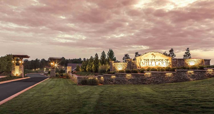Entrance view of The Springs of Mill Lakes with a welcoming sign.