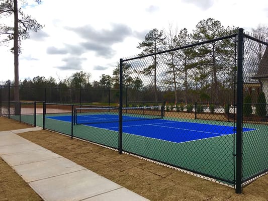 Tennis court with blue surface and chain-link fence