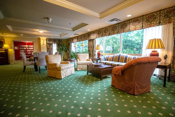Lounge area with seating and large windows in The St. Paul Senior Living Community