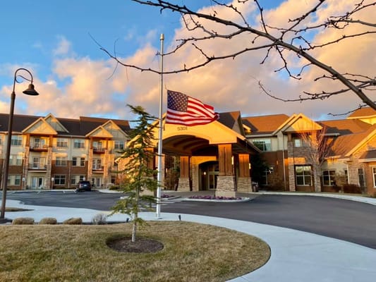 The entrance of The Terraces of Boise with an American flag and trees in the foreground.