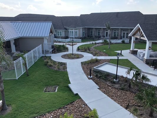 View of landscaped pathways and gardens at The Viera Senior Living facility