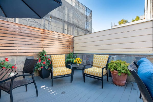 Outdoor seating area with flowers and sunflowers