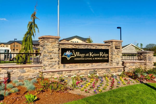 Sign at The Village at Keizer Ridge with landscaped flowers