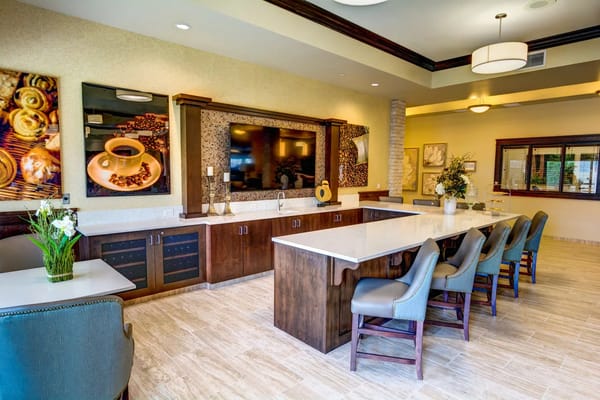 A modern kitchen with a large island and seating at The Village at Keizer Ridge.