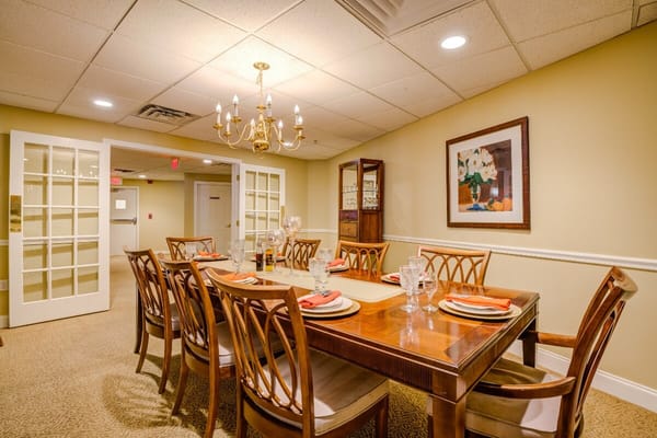 Interior view of the dining room with a large wooden table set for a meal