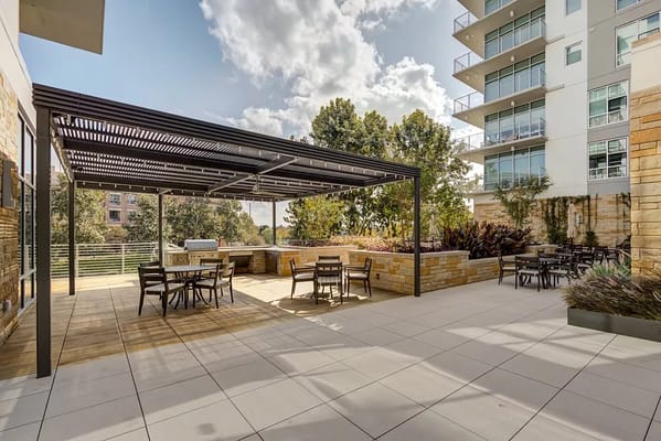 Outdoor seating area with shaded pergola and gardens