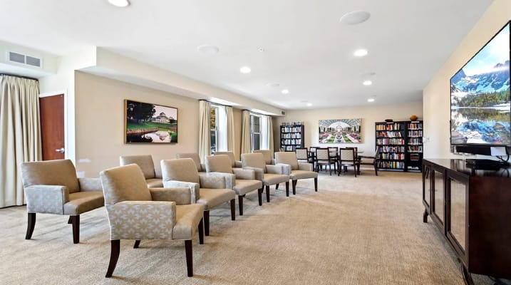 Cozy lounge area with comfortable seating and shelves of books.