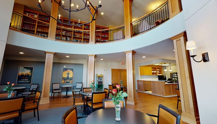Interior view of a library and common area with tables and chairs.