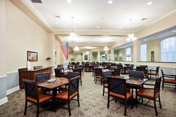 Dining area with tables and chairs in the Wellington at Arapaho facility