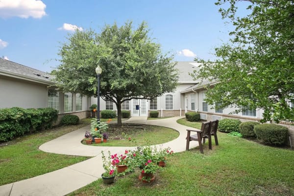 Lush courtyard with flowers and seating area at The Wellington at Arapaho.
