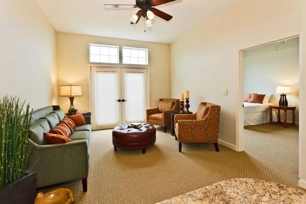 A well-furnished living room with a green sofa and two patterned armchairs