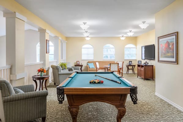 Billiards table in a relaxed lounge area with seating and natural light