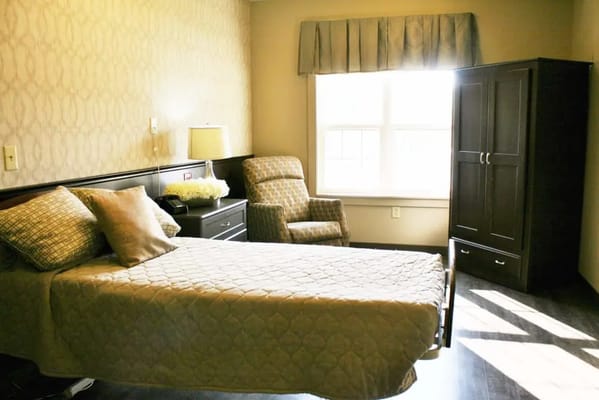 Comfortable bedroom with a bed, armchair, and wardrobe.