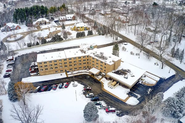 Aerial image of The Woods of Caledonia senior living facility surrounded by snow-covered landscape.