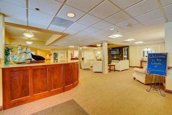 Welcoming lobby area with seating and reception desk at The Woods of Caledonia.