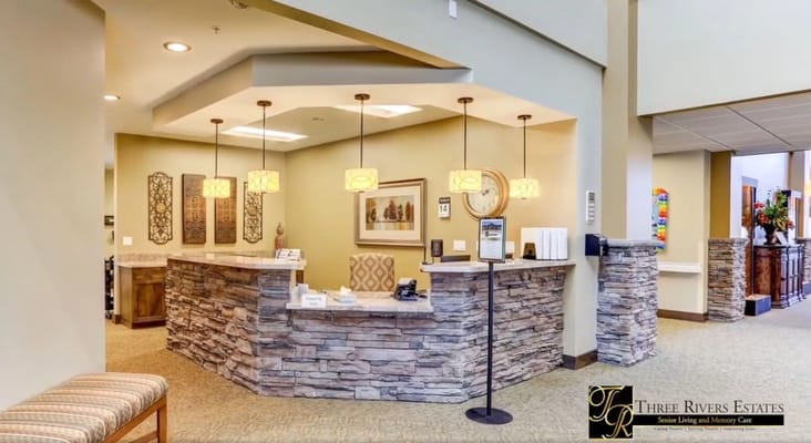 Welcoming reception area with stone-accented desk and ambient lighting.
