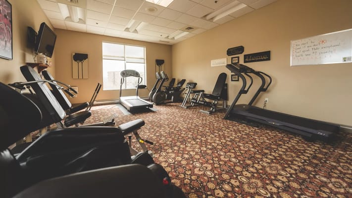 Fitness room with exercise equipment and large windows