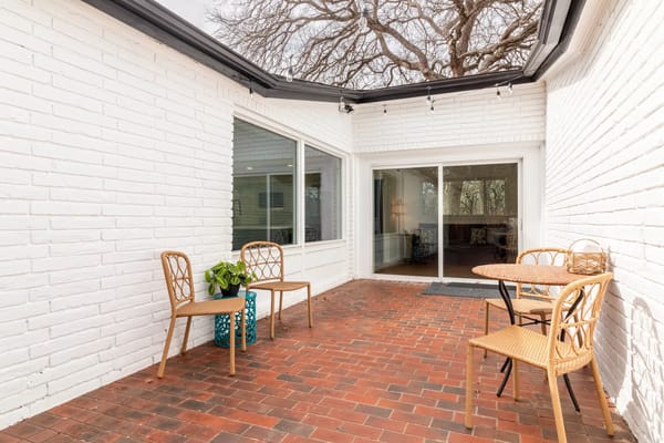 Outdoor seating area with chairs and a plant