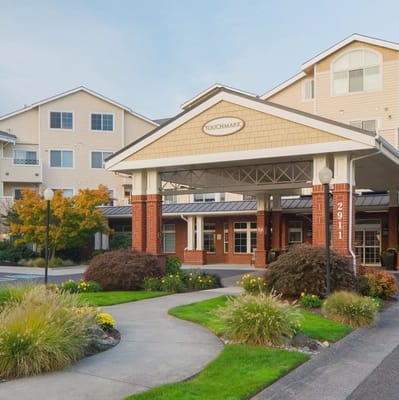 The front entrance of Touchmark at Fairway Village with a pathway and landscaping.